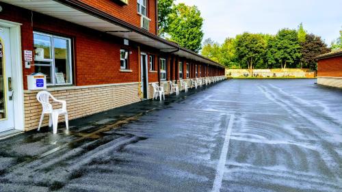 a row of white chairs sitting outside of a building at Kings Inn Midland in Midland