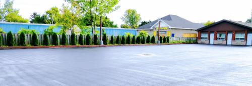 a parking lot in front of a building with a fence at Kings Inn Midland in Midland