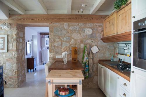a kitchen with a table and a stone wall at Charming rustic house in Gardone Riviera