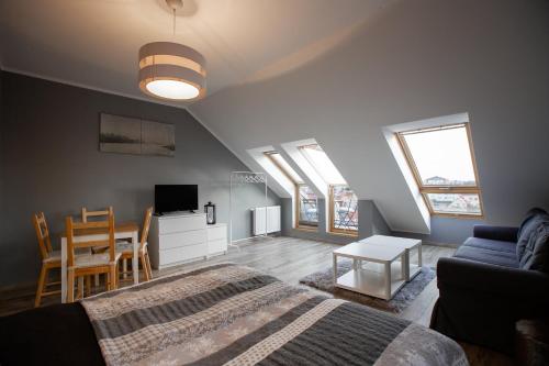 ein Schlafzimmer mit einem Bett, einem Sofa und einem Tisch in der Unterkunft Apartament nad morzem in Darłówko