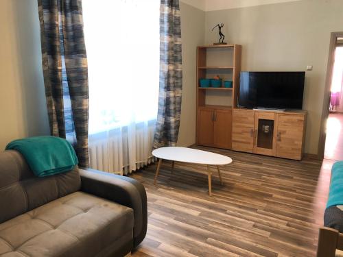 een woonkamer met een bank en een tv bij Apartment "Flowers" in Rīga