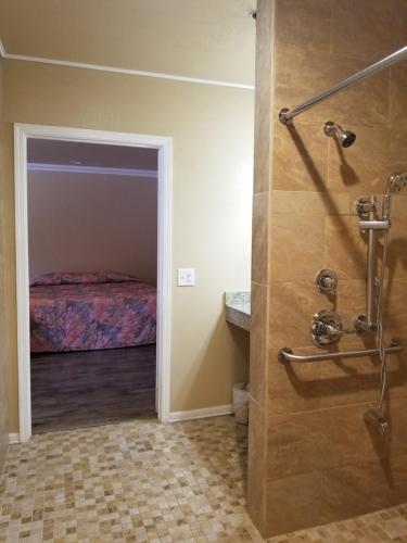 Cette chambre comprend un lit et une salle de bains pourvue d'une douche. dans l'établissement Welcome Inn & Suites Anaheim, à Anaheim