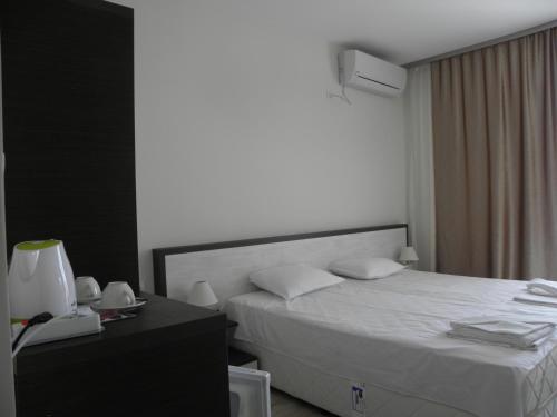 Habitación de hotel con cama y mesa con teléfono en Hypnotic Complex, en Nesebar