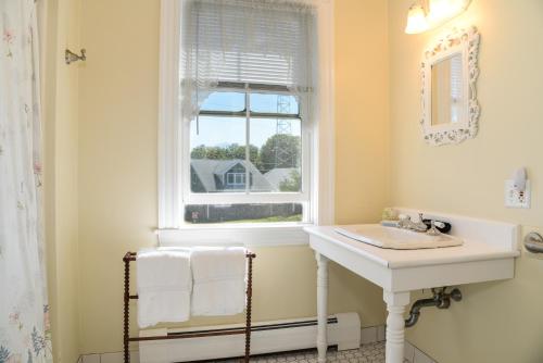 uma casa de banho com um lavatório e uma janela em Payne's Harbor View Inn em New Shoreham