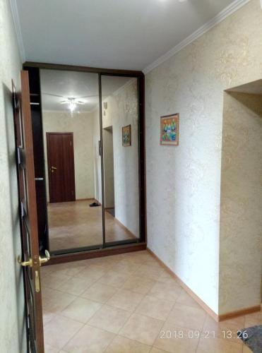 an empty room with a glass door and a hallway at Уютная квартира in Kyiv
