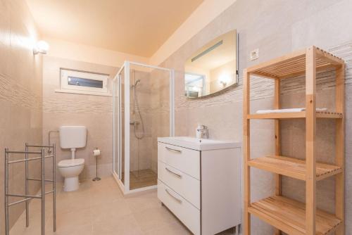 a bathroom with a toilet and a shower and a sink at Villa Sandra in Lumbarda