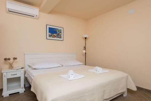 a bedroom with a bed with two towels on it at Villa Sandra in Lumbarda