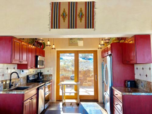 a kitchen with red cabinets and a sink at The Casita del Lago in Abiquiu