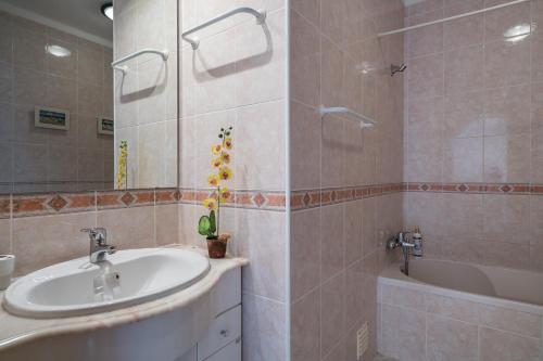 een badkamer met een wastafel en een bad bij Vilamoura WOWlidays in Vilamoura