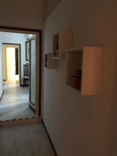 a hallway with a door to a room with a plant on a wall at Villa Giove Rooms in Prato