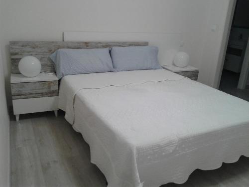 ログローニョにあるApartamento Gran Via Logroñoのベッドルーム1室(白いベッド1台、ナイトスタンド2台付)