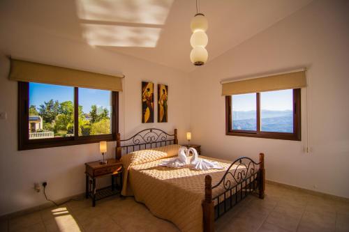 um quarto com uma cama e duas janelas em Alkiviades Villa em Theletra
