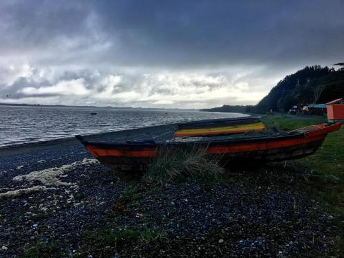 dos barcos sentados en la orilla de un cuerpo de agua en Caulín Lodge, en Chacao