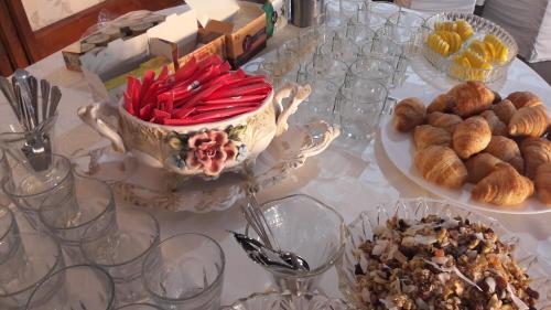 a table topped with plates of food and bowls of pastries at Pensiunea Jacqueline in Târgu Jiu