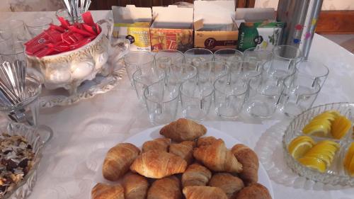 a table topped with plates of pastries and wine glasses at Pensiunea Jacqueline in Târgu Jiu