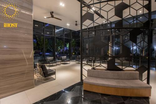 a lobby with a couch and chairs in a building at Expressionz Suites By iHost Global in Kuala Lumpur