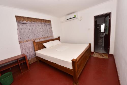 a small bedroom with a bed and a window at Pidurangala View Home Stay in Sigiriya
