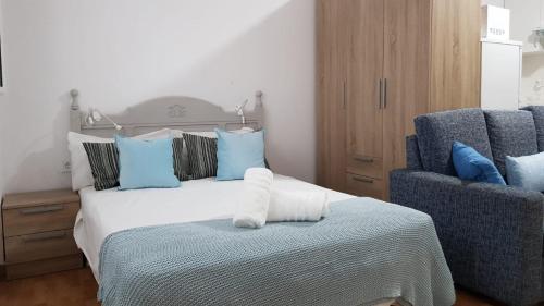San NicolásにあるLoft en La Aldea de San Nicolasのベッドルーム1室(ベッド1台、青い椅子2脚付)