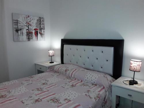een slaapkamer met een bed met 2 tafels en 2 lampen bij Ignea in Cordoba