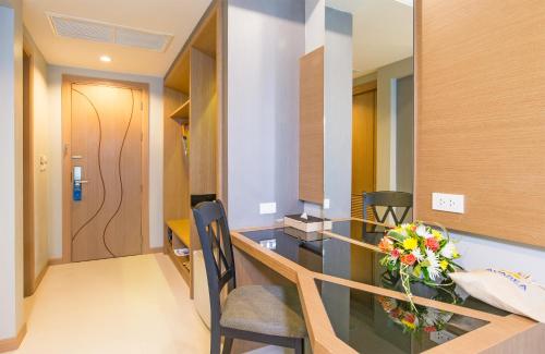 a room with a table with a vase of flowers at AVA SEA Ao Nang Beach Resort-SHA Extra Plus in Ao Nang Beach