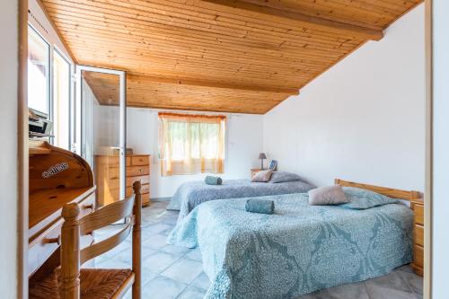 two beds in a room with wooden ceilings at La maison des vacances in Menton