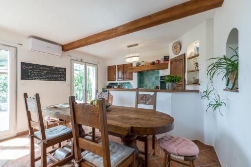 une cuisine et une salle à manger avec une table et des chaises en bois dans l'établissement La maison des vacances, à Menton