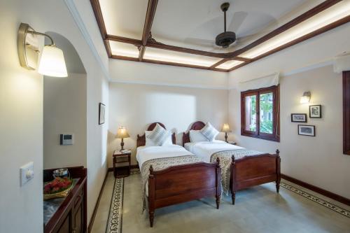 a bedroom with two beds and a ceiling at Le Bel Air Resort Luang Prabang in Luang Prabang