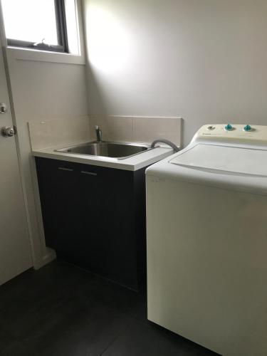 a small kitchen with a sink and a refrigerator at Peterborough Getaway in Peterborough