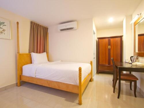 a bedroom with a bed and a desk and a desk at Lotus Hotel Masjid India in Kuala Lumpur