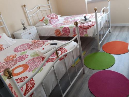 2 camas individuales en una habitación con alfombras coloridas en Casa da Maria, en Alcobaça