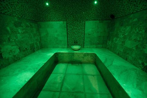 a green room with a tub with a bowl in it at Best Western Plus Astana Hotel in Astana
