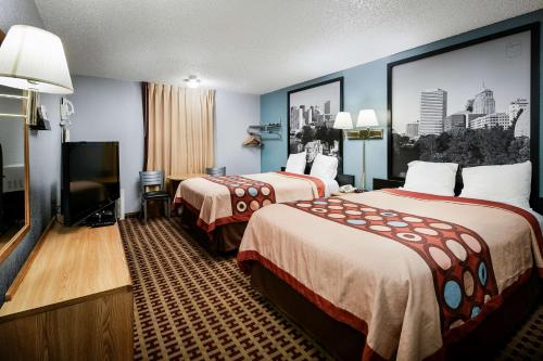 エルクシティにあるSuper 8 by Wyndham Elk Cityのベッド2台、薄型テレビが備わるホテルルームです。