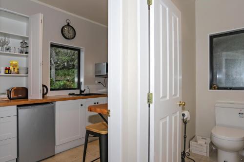 a bathroom with a toilet and a sink at Three Gables B&B in Whakamarama