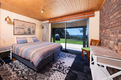 Schlafzimmer mit einem Bett und einem Fenster in der Unterkunft Magic Mountain at Smiths Lake in Smiths Lake