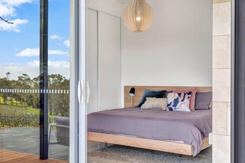 a bedroom with a bed and a sliding glass door at Shadow Creek McLaren Vale in McLaren Vale