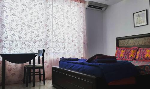 a bedroom with a bed and a table and a chair at Rahul Residency in Mangalore