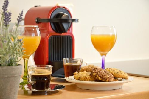 a table with a plate of food and two glasses of orange juice at Bella's Rustic Suites in Nafplio