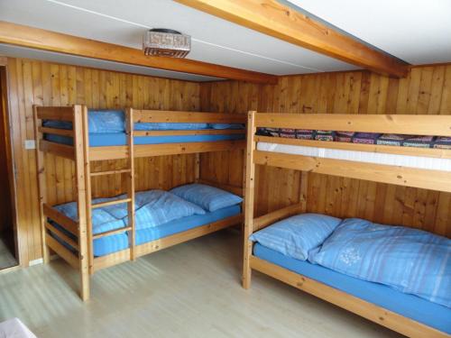 2 Etagenbetten in einem Zimmer mit Holzwänden in der Unterkunft Ferienhaus Gubel in Alt Sankt Johann