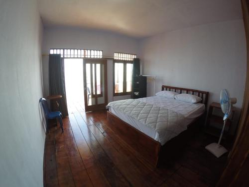 um quarto com uma cama e piso em madeira em Ora Sunrise View em Kaloa