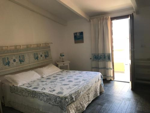 a bedroom with a bed and a large window at Appartamento Via Sassari in Alghero