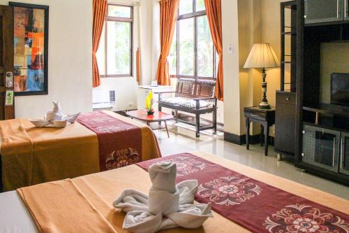 a hotel room with two beds and a towel animal sitting on a bed at Stone House Quezon City in Manila