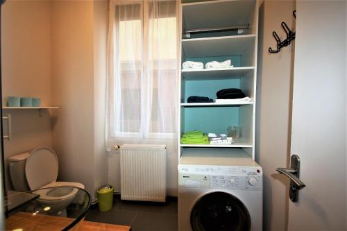 a kitchen with a washing machine in a room at Escale meublée in Belfort