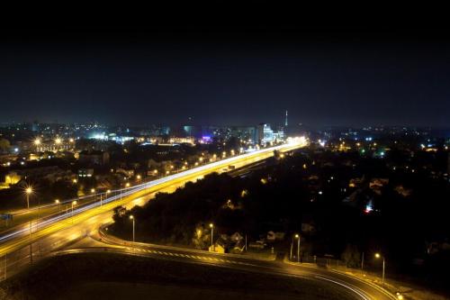 a city lit up at night with traffic on a highway at Apart Panorama in Lviv
