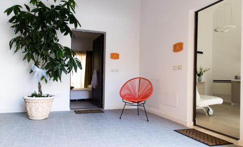 une chaise rouge assise dans un couloir avec une plante dans l'établissement Borgo Fratta Holiday Houses, à Umbertide