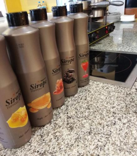 Een rij van vijf shampooflessen op een aanrecht in de keuken. bij Fenals Garden in Lloret de Mar