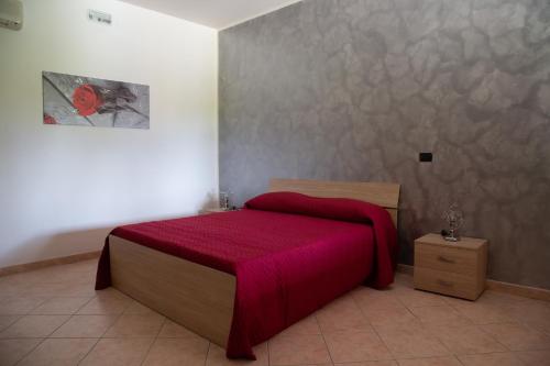 a bedroom with a bed with a red blanket at B&B Villa dei Sogni in Eboli
