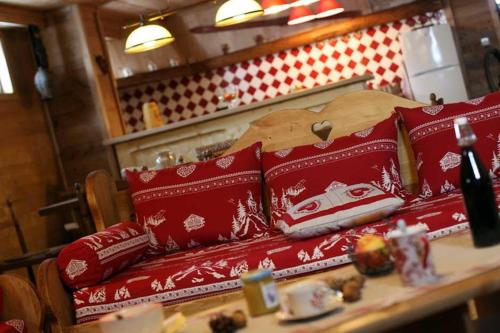 une table recouverte d'oreillers rouges de Noël sur une table dans l'établissement Chalet du champ Martel, à Villard-de-Lans