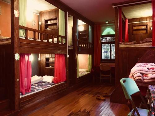 麗江的住宿－湯姆家客棧，客房配有带红色窗帘的双层床。