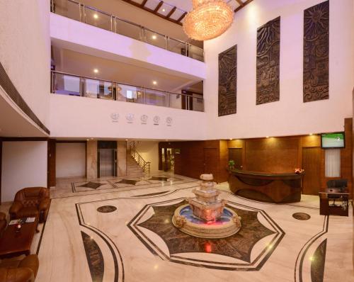 a large lobby with a fountain in the middle at Keshav Clarks Inn Gadag in Gadag