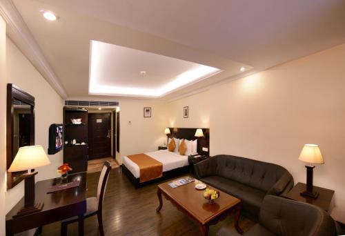 a living room with a couch and a bed in a room at Keshav Clarks Inn Gadag in Gadag